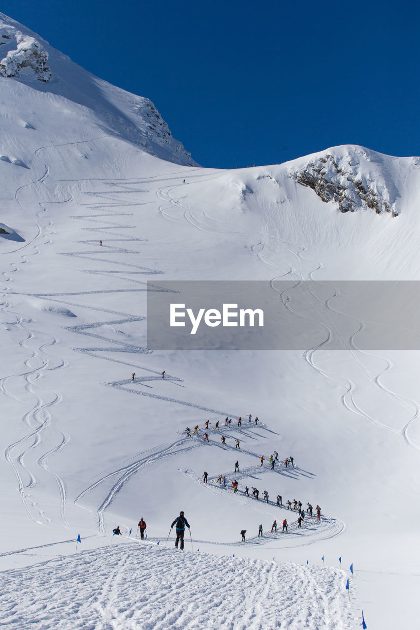 Group of people skiing on snowcapped mountain