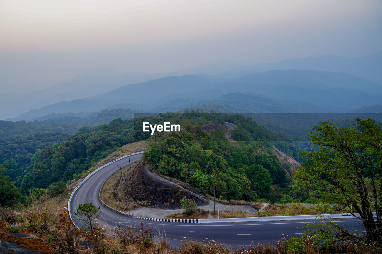 High angle view of road amidst trees against sky