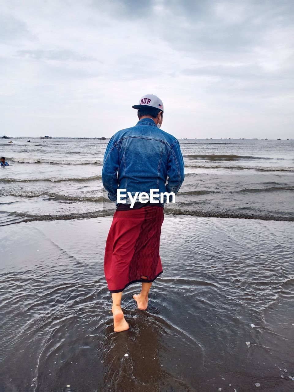 FULL LENGTH REAR VIEW OF MAN STANDING ON BEACH