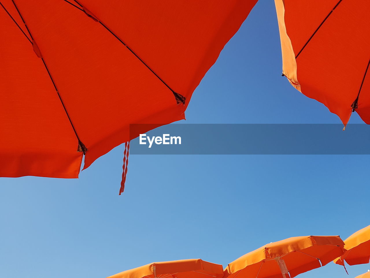 Low angle view of beach umbrella hanging against sky