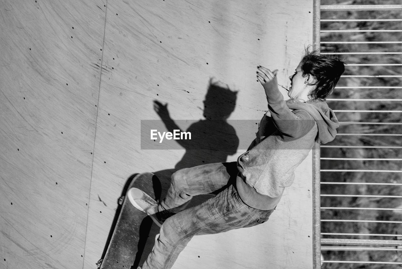 Young woman skateboarding on ramp at park during sunny day