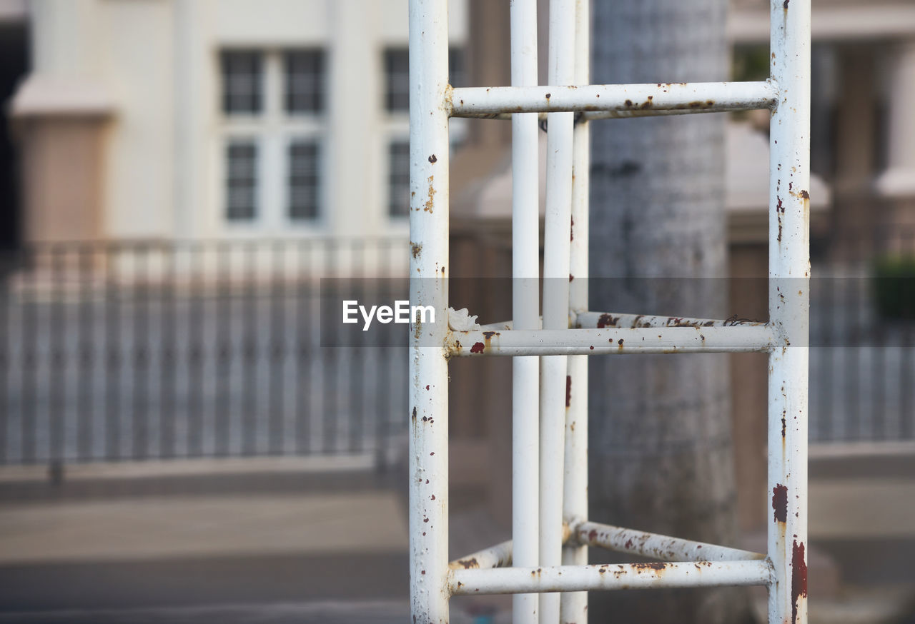 Close-up of metal fence against building