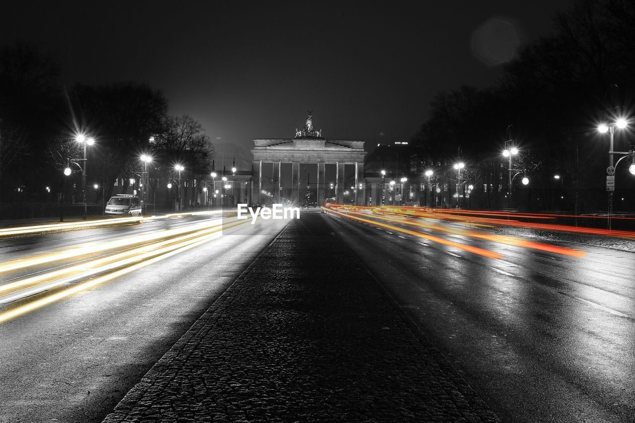 Light trails on road against sky at night