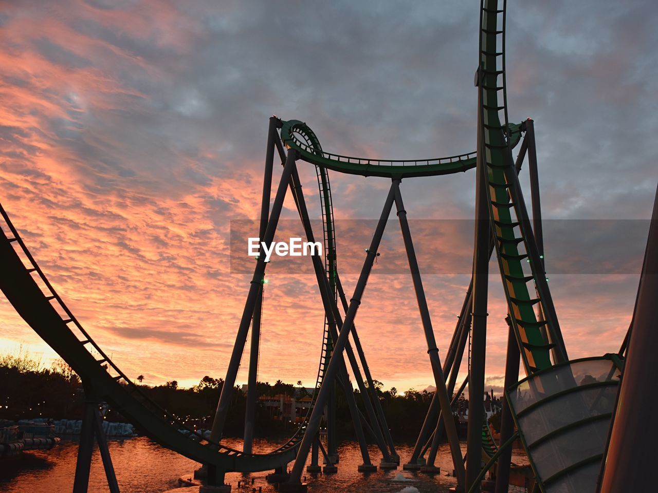 LOW ANGLE VIEW OF ROLLERCOASTER AGAINST SKY DURING SUNSET