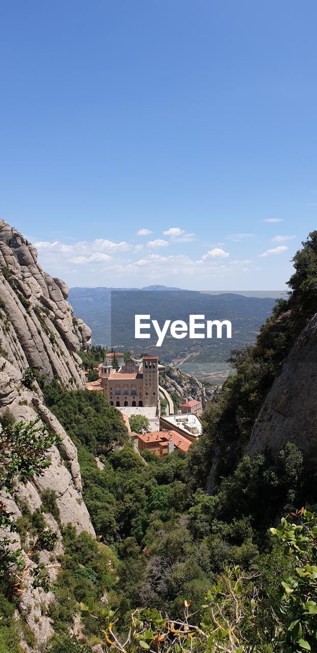 Scenic view of mountains and buildings against sky