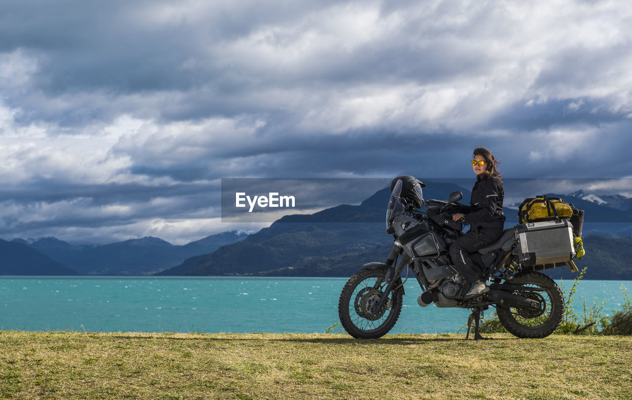 Woman sitting on enduro touring motorbike at lago rio tranquillo