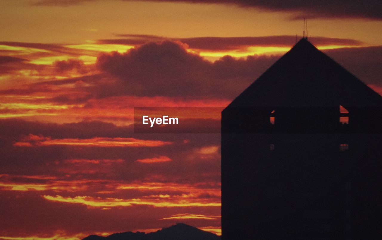 CLOSE-UP OF SILHOUETTE BUILDING AGAINST SKY