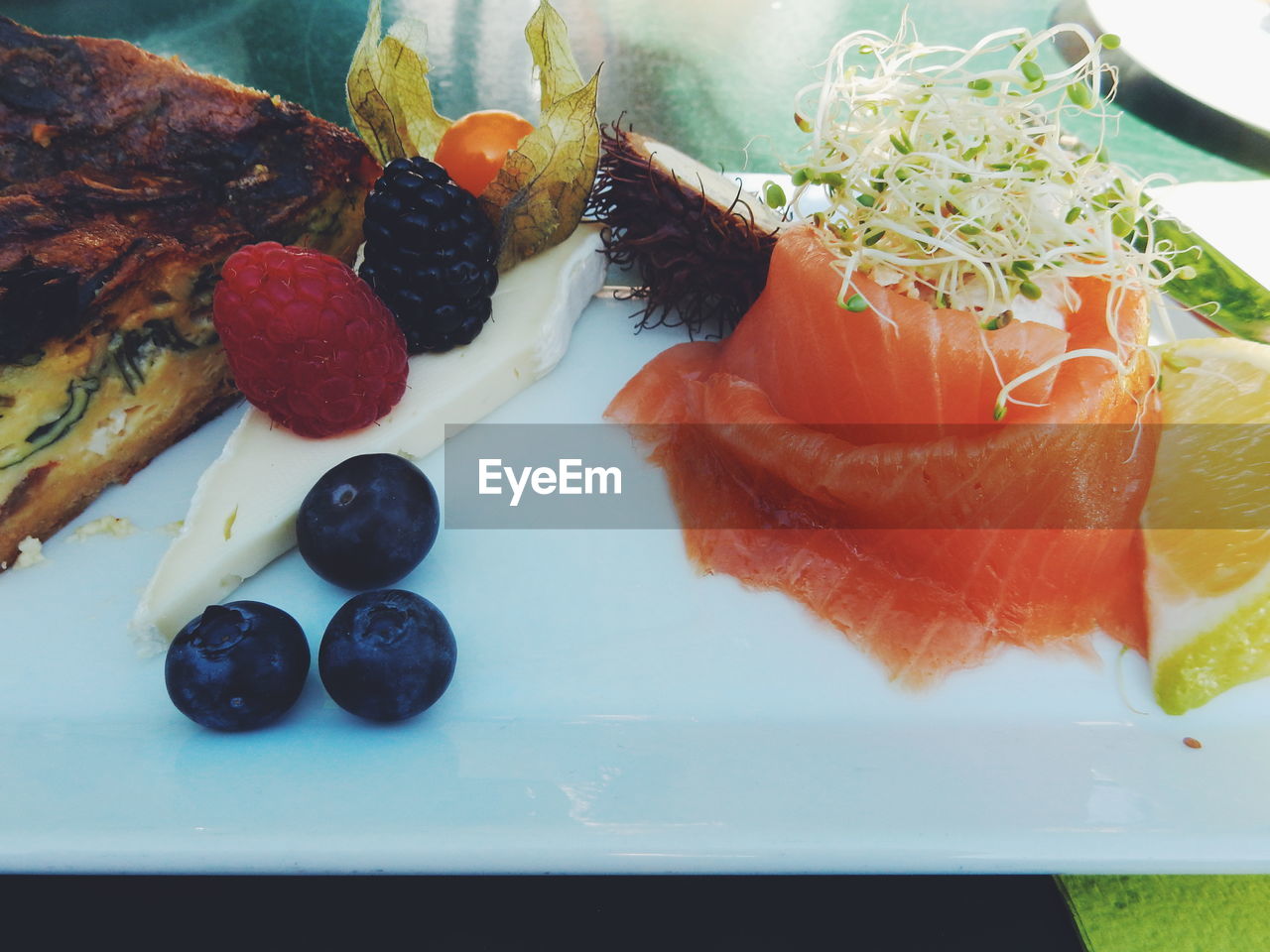 High angle view of fruits and smoked salmon on table