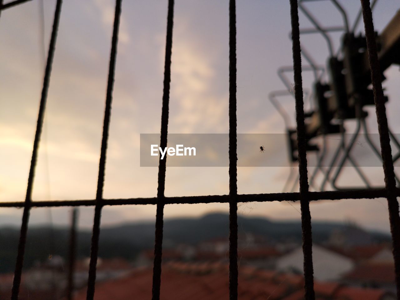 CLOSE-UP OF METAL FENCE AGAINST SKY