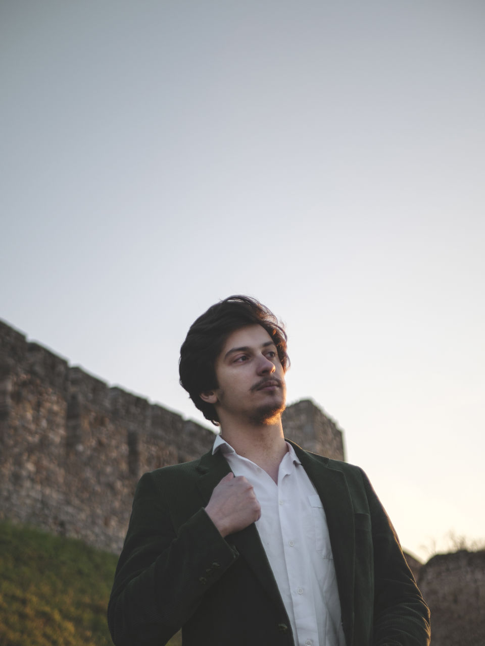 PORTRAIT OF MAN LOOKING AWAY AGAINST CLEAR SKY