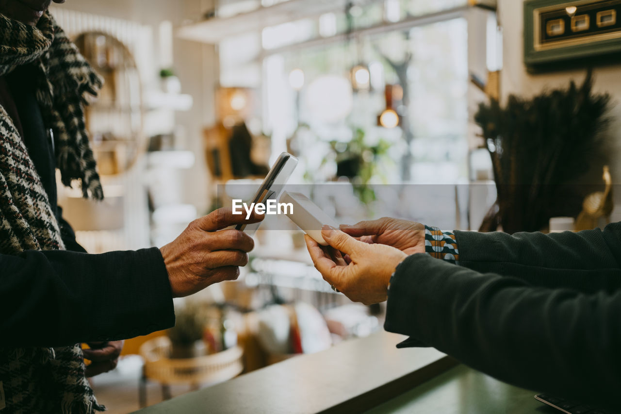 Male customer paying via tap to pay method while doing shopping at store