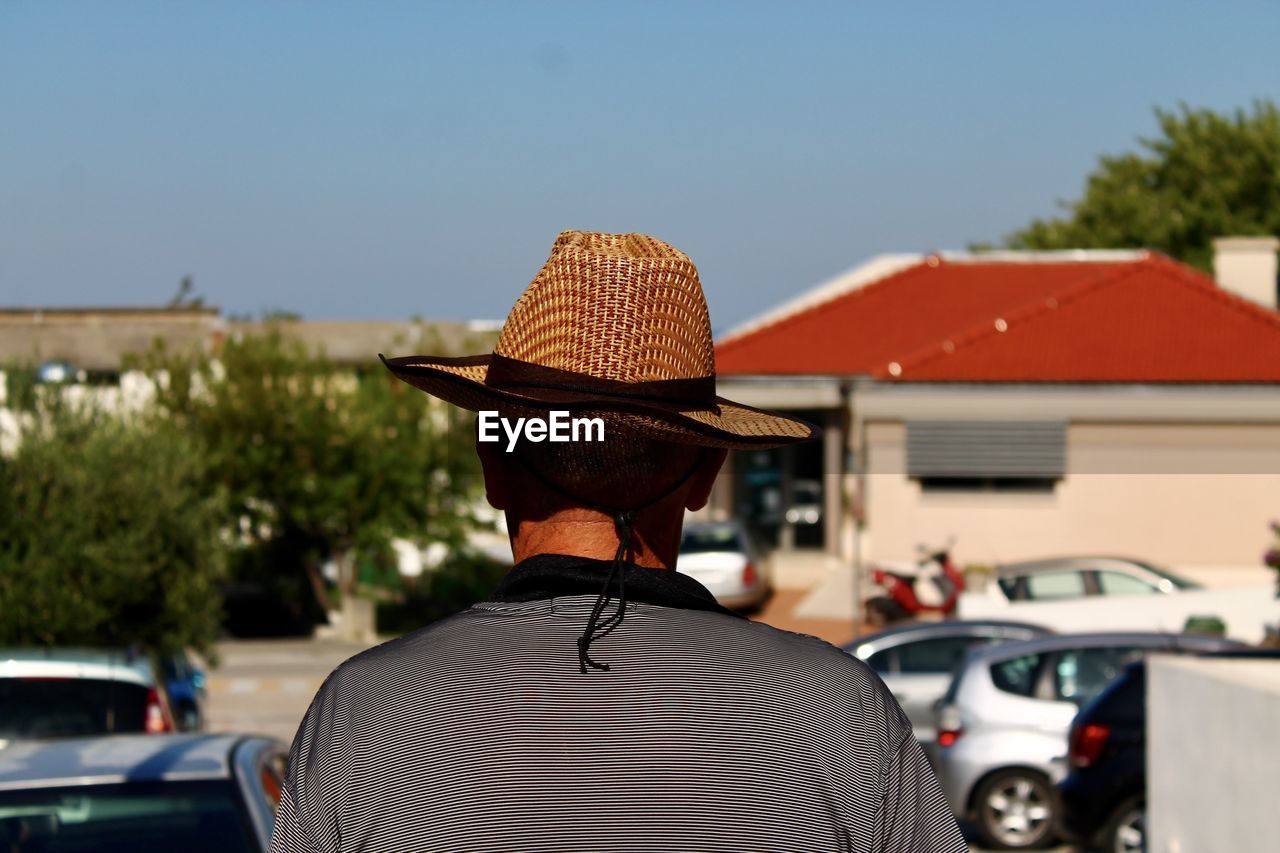 REAR VIEW OF MAN IN HAT AGAINST SKY