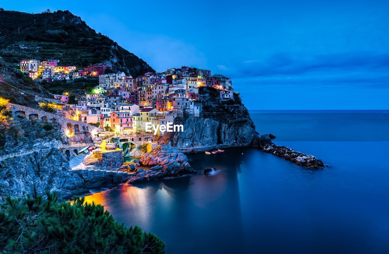 Illuminated old buildings on shore