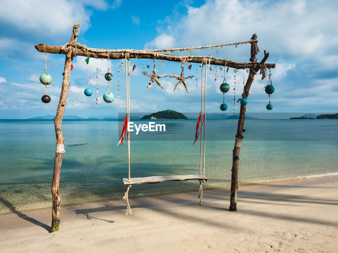 Scenic tropical island with wooden beach swing and turquoise sea. koh mak island, trat, thailand.