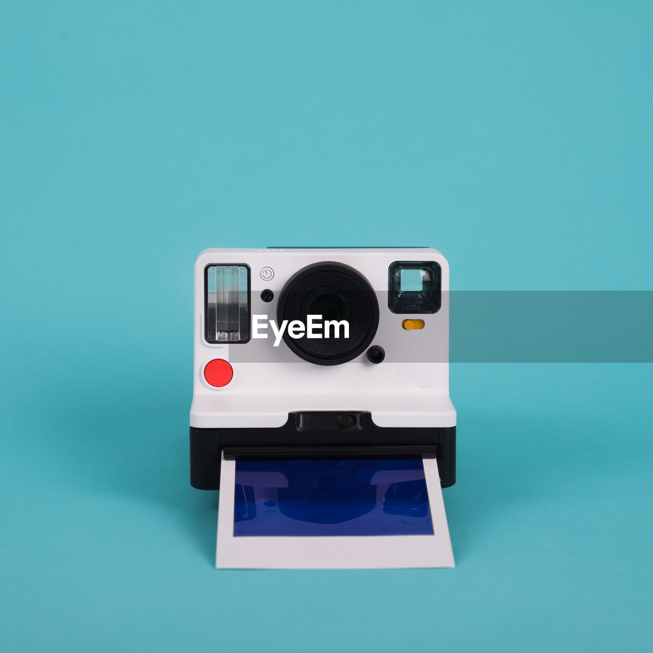 Close-up of instant camera against blue background