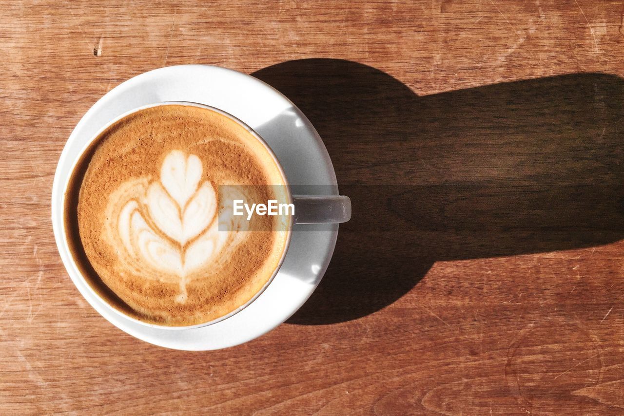 Directly above shot of cappuccino on table during sunny day