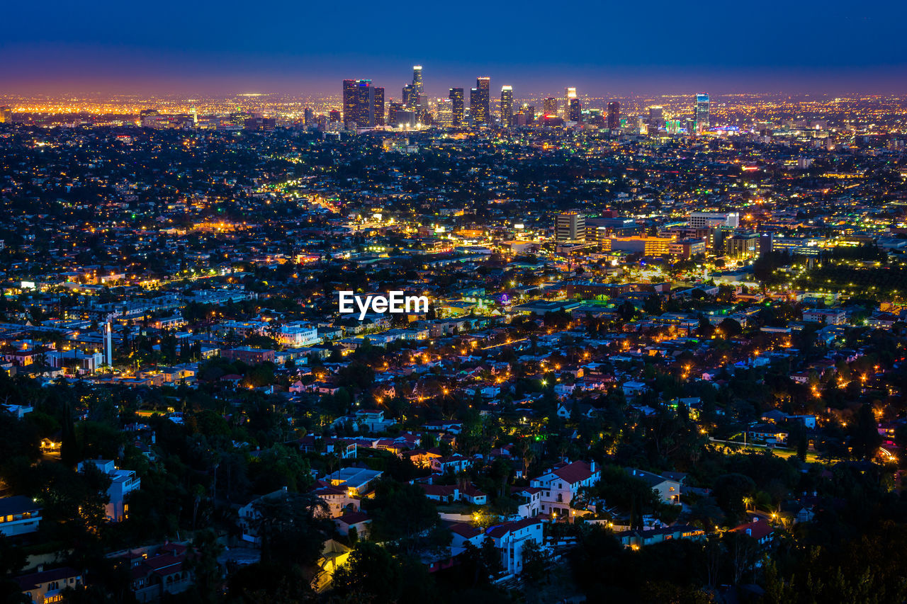 HIGH ANGLE VIEW OF ILLUMINATED CITYSCAPE AGAINST SKY