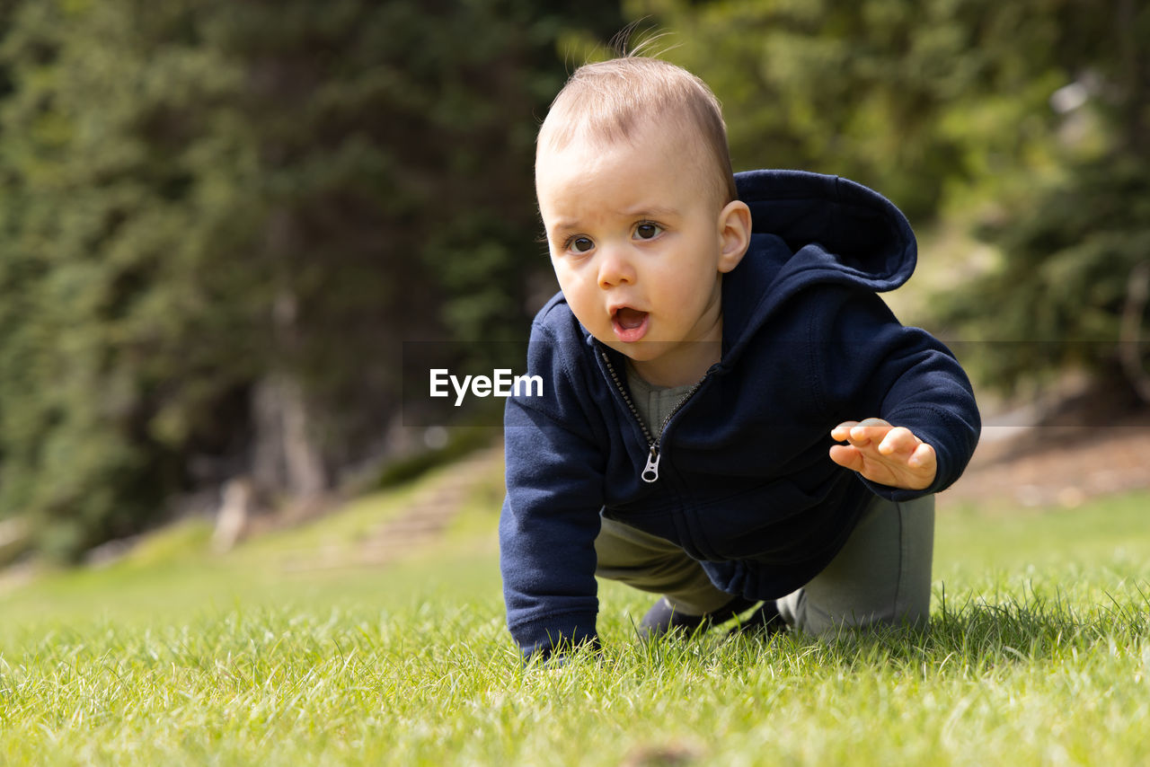 portrait of cute boy standing on grassy field