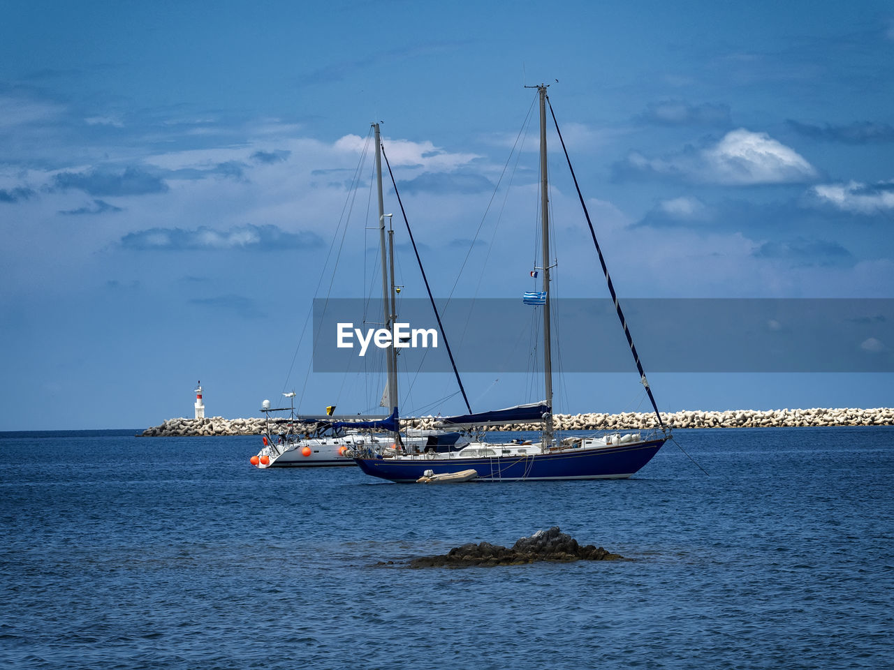 Sailboat sailing on sea against sky