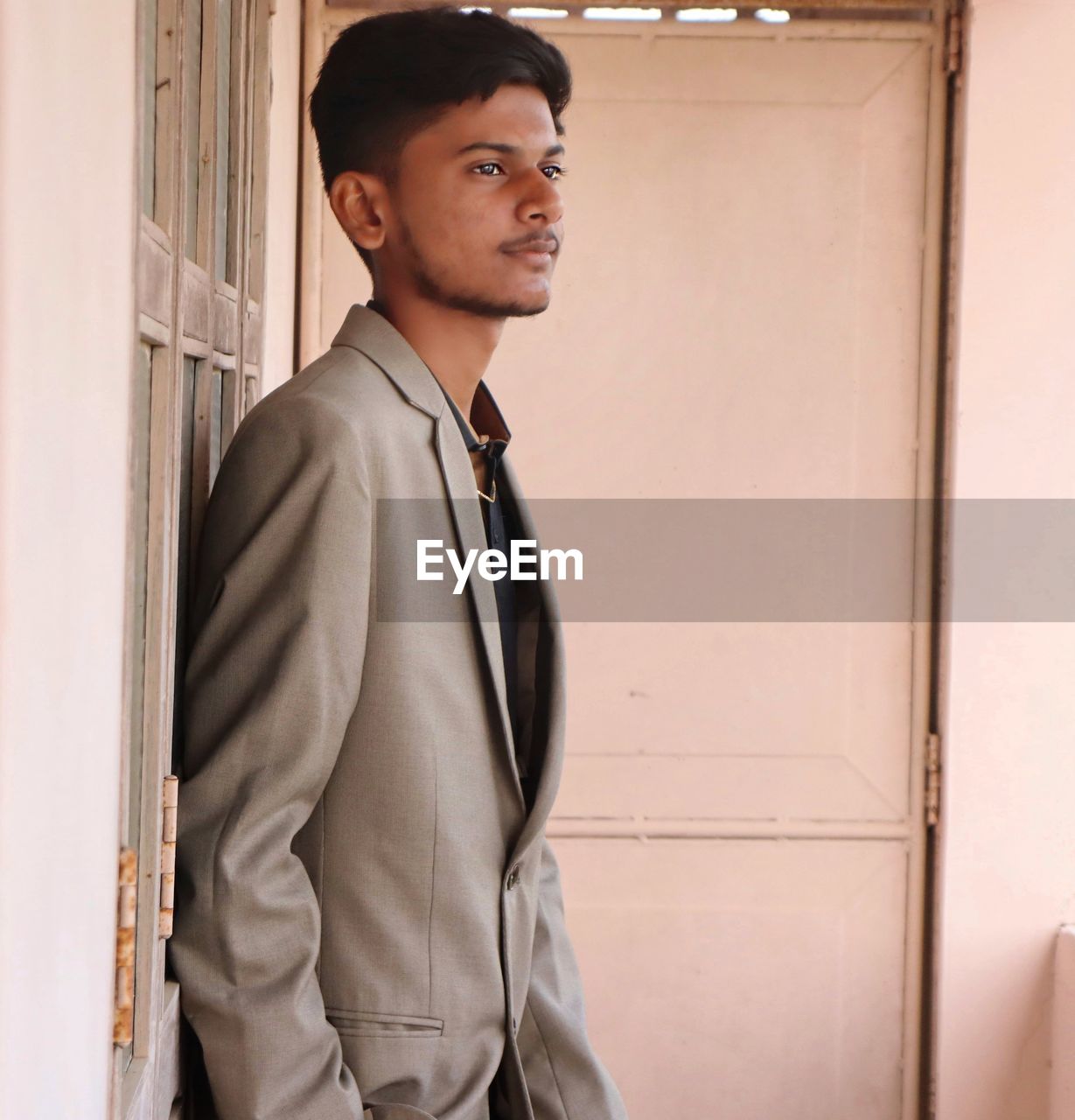Young man standing against wall