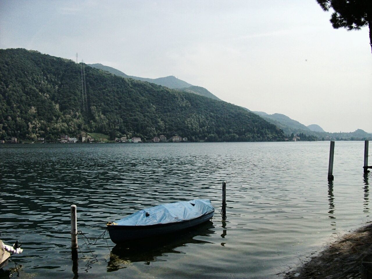 BOAT MOORED BY LAKE AGAINST SKY