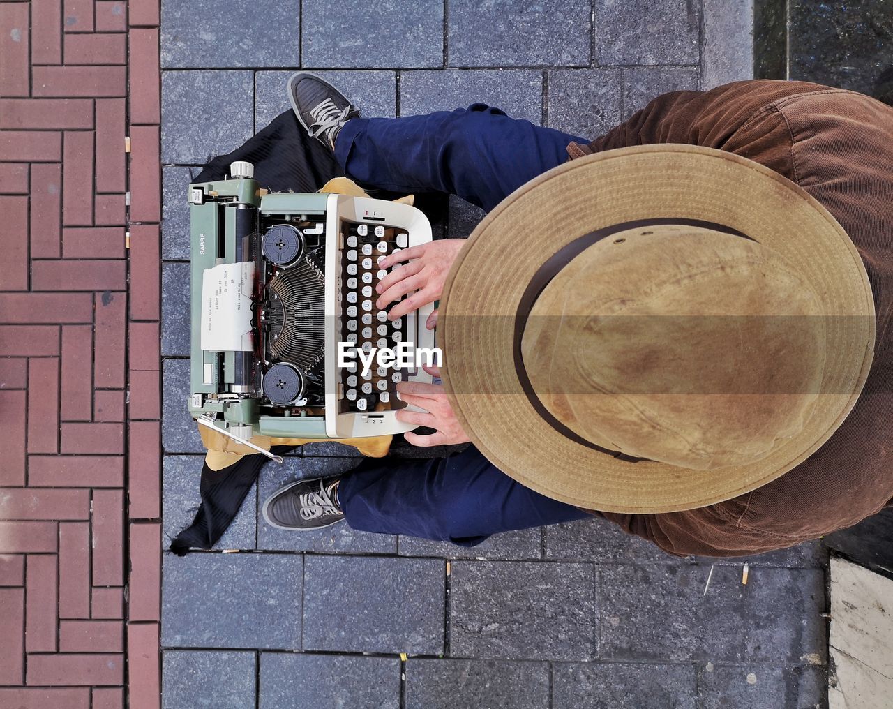 High angle view of person typing on typewriter in city