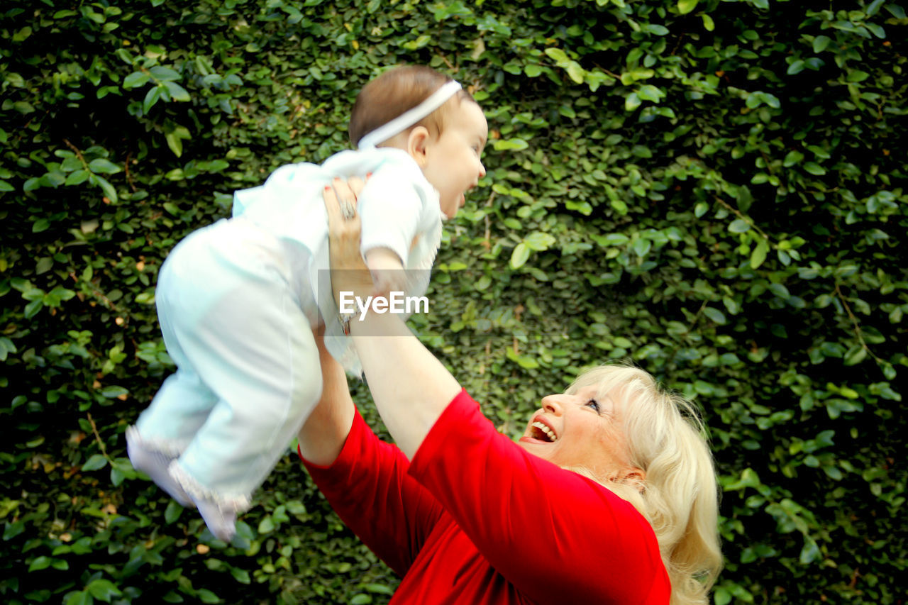 Senior woman enjoying with baby girl at back yard