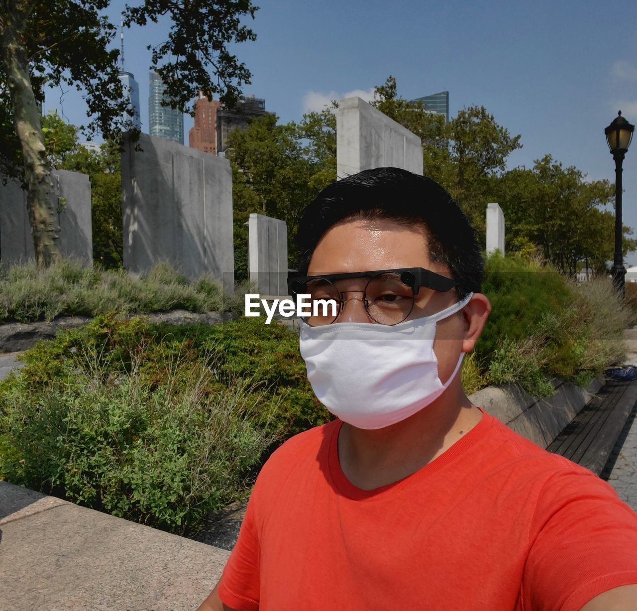 PORTRAIT OF MAN STANDING BY PLANTS