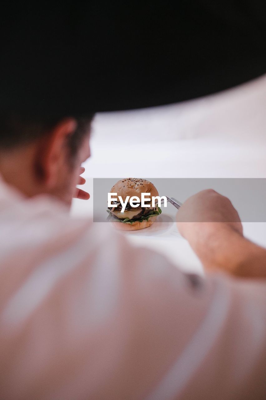 Close-up of hand preparing a burger