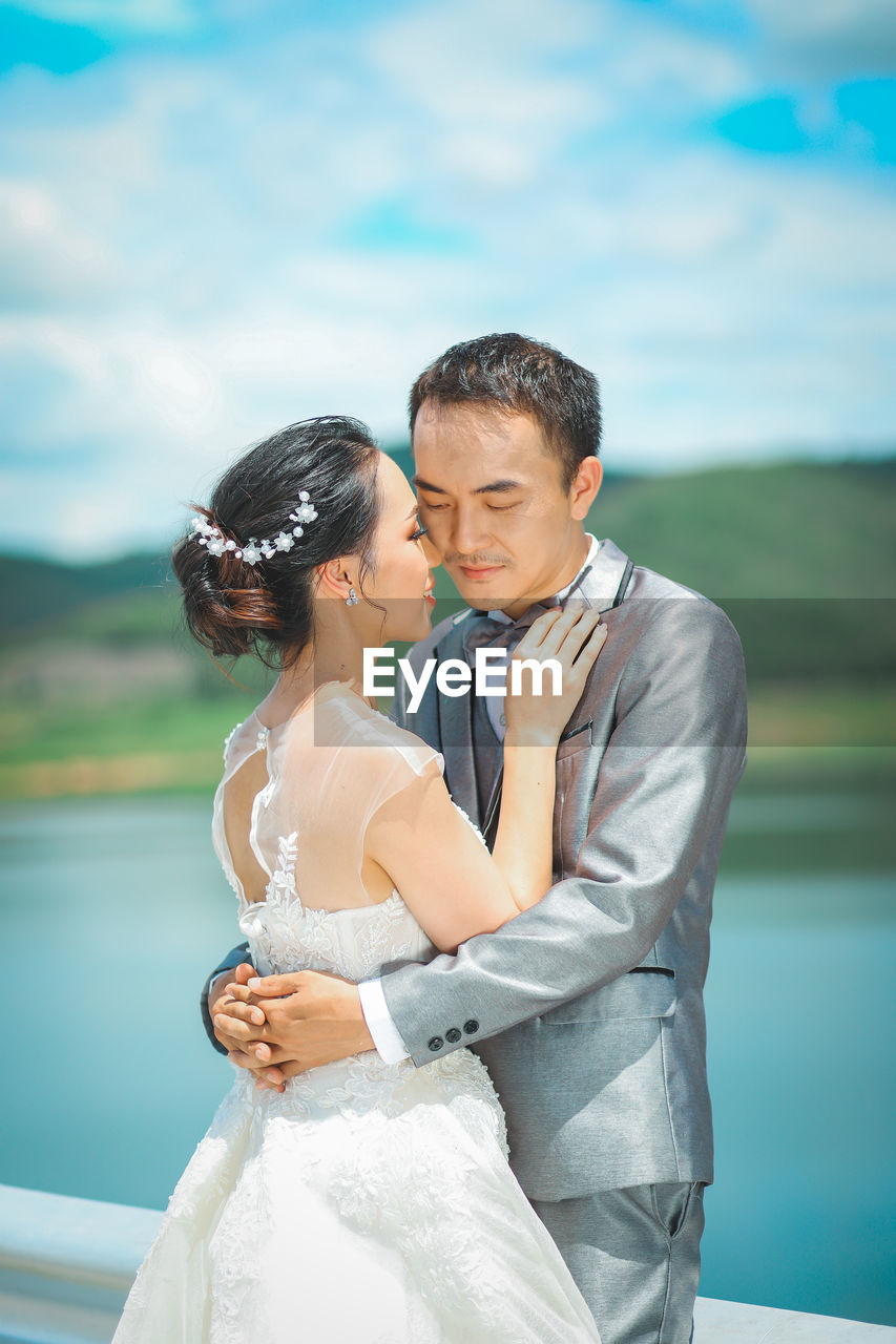 Couple standing against lake