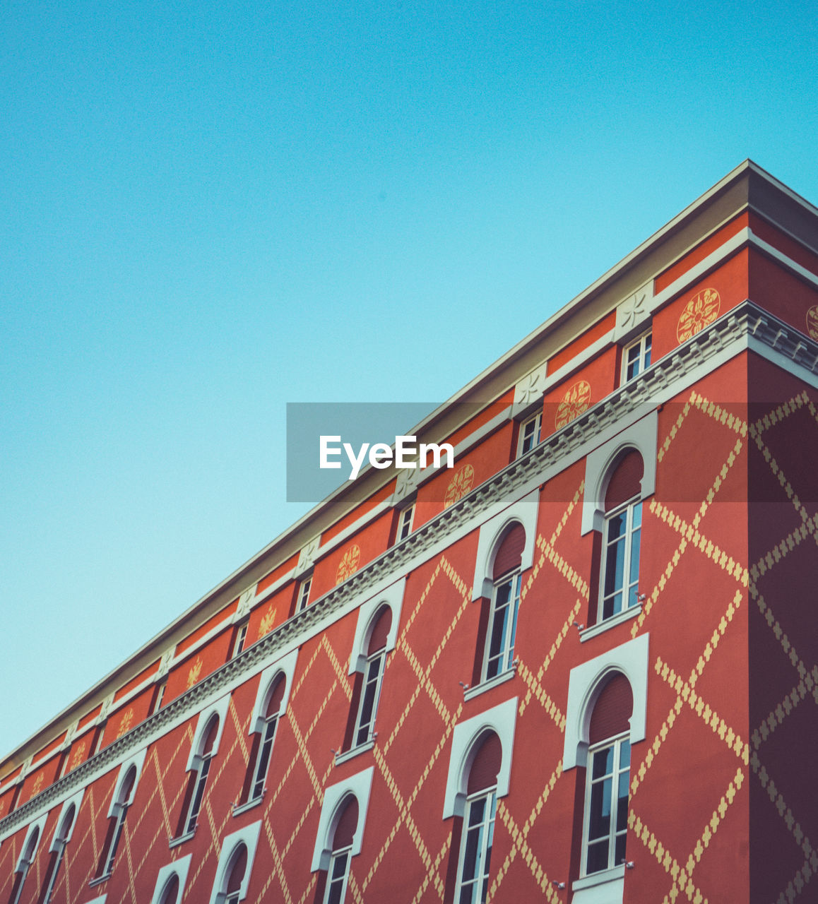 LOW ANGLE VIEW OF BUILDING AGAINST CLEAR BLUE SKY IN CITY