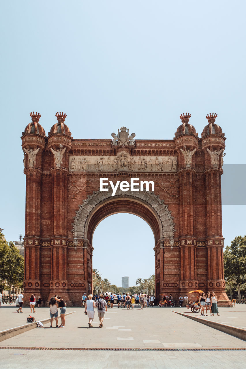 Group of people in front of historical building arco de triunfo barcelona