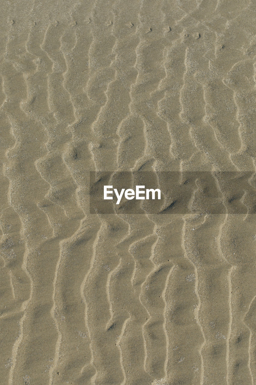 Minimalistic high angle view of wave pattern on sand at beach