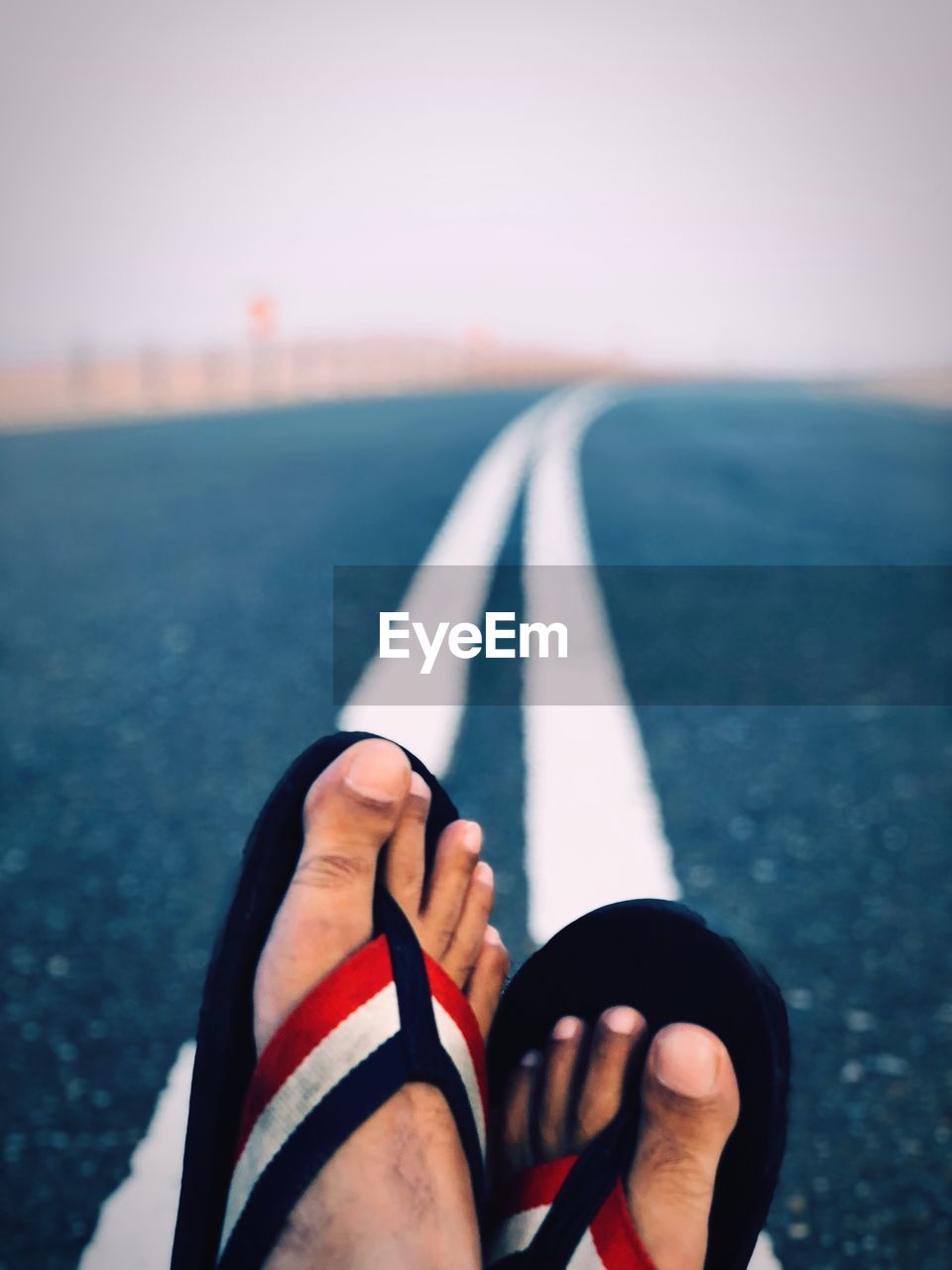 Low section of man relaxing on road