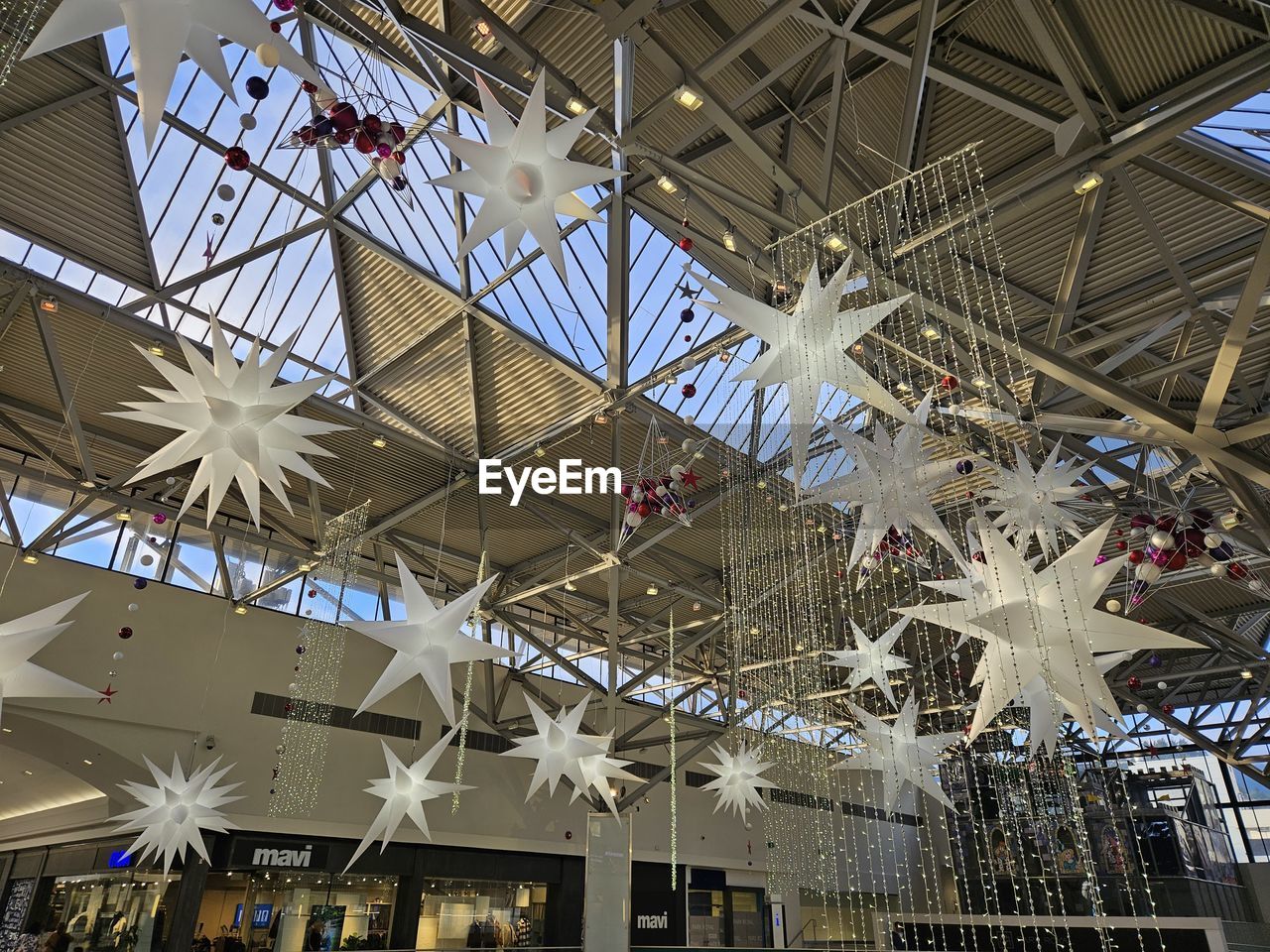 ceiling, built structure, indoors, architecture, low angle view, no people, shopping mall, glass, hanging, travel, day