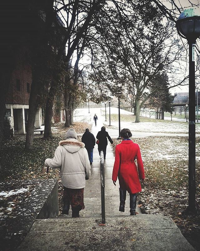 REAR VIEW OF WOMAN WALKING ON FOOTPATH