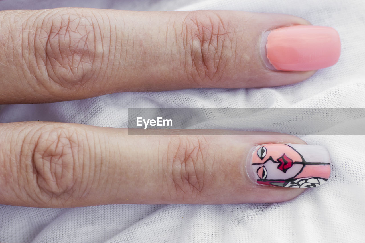 CLOSE-UP OF HUMAN HAND WITH TATTOO ON FINGER