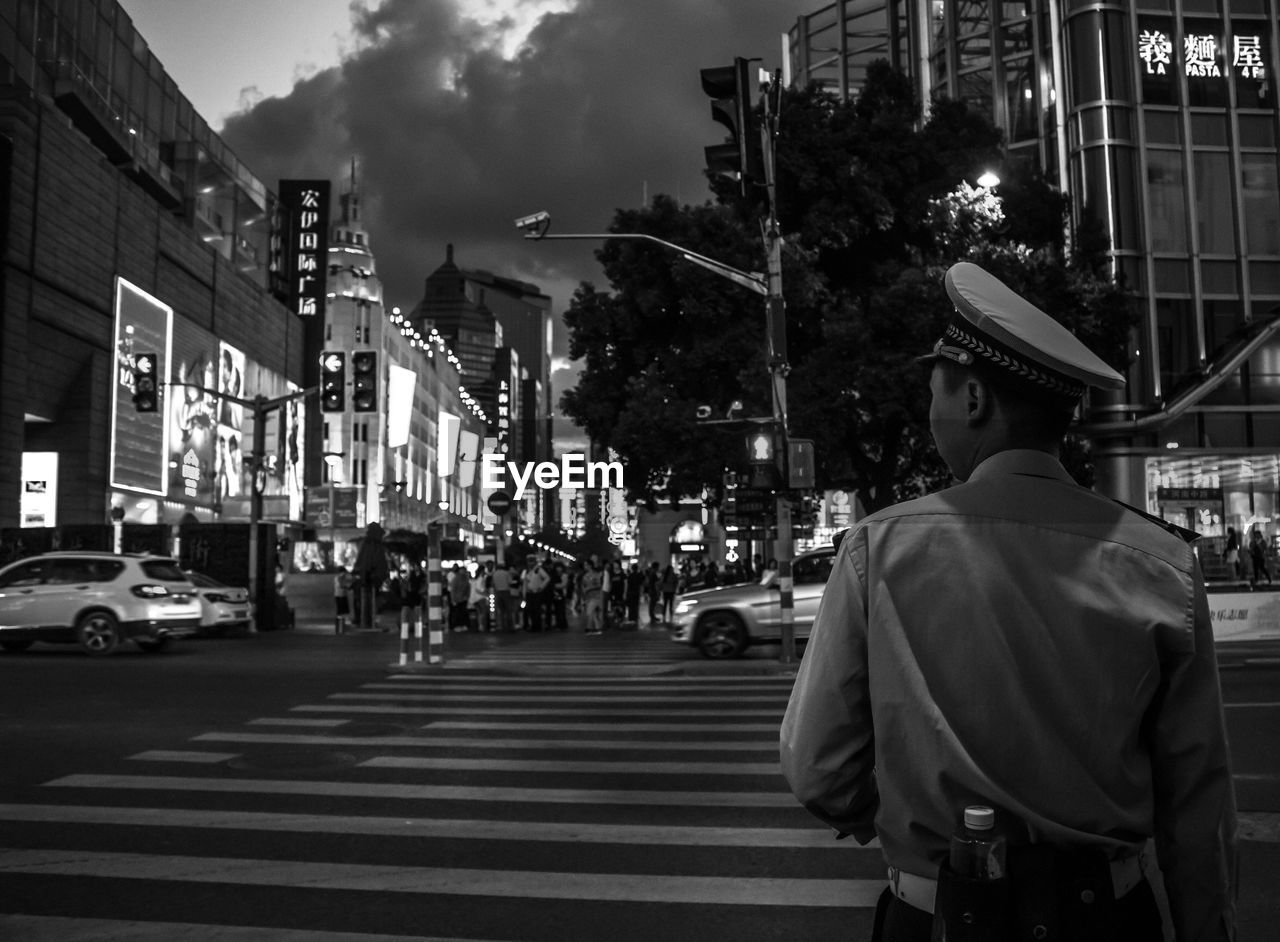 Police man standing on road in city