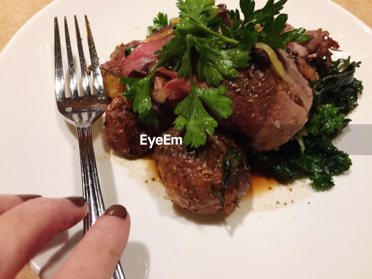 CLOSE-UP OF HAND HOLDING MEAT WITH SALAD