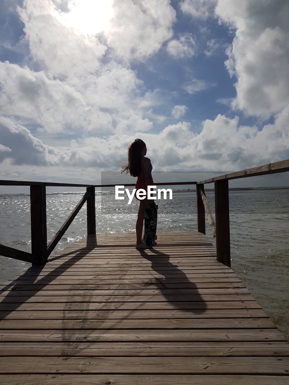 Full length of woman standing on pier over sea