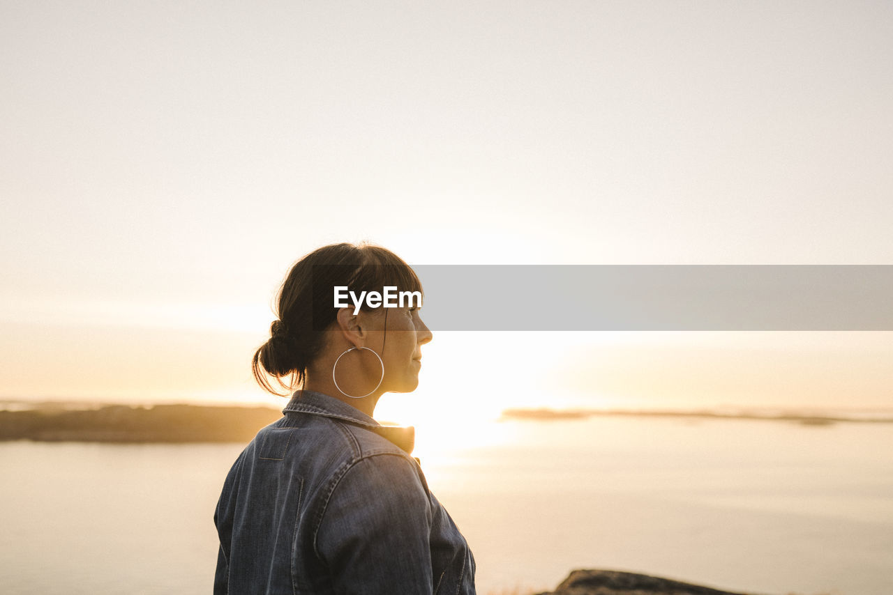 Woman looking at sunset over sea