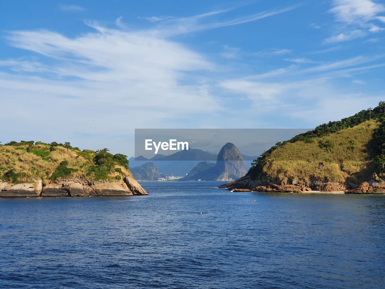 SCENIC VIEW OF SEA BY MOUNTAIN AGAINST SKY