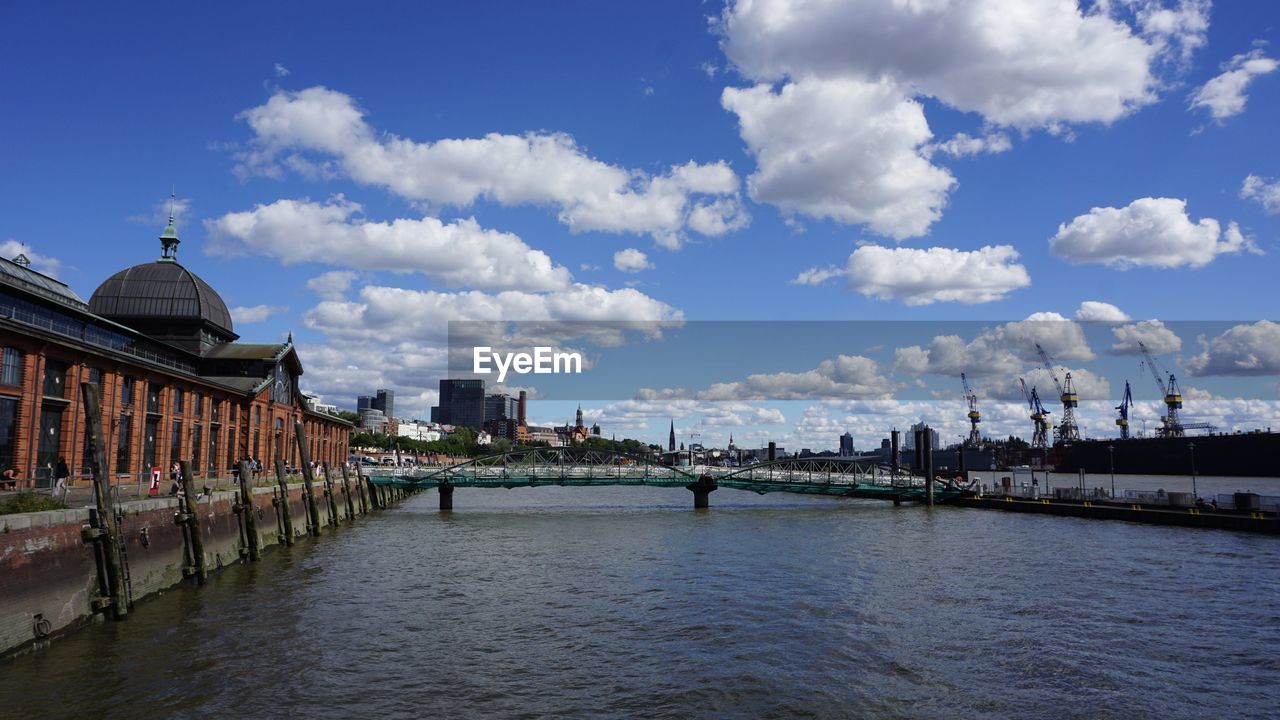 Bridge over river against buildings in city