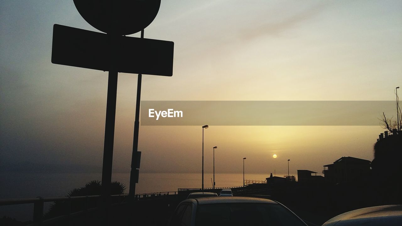 Street light on road against sky at sunset