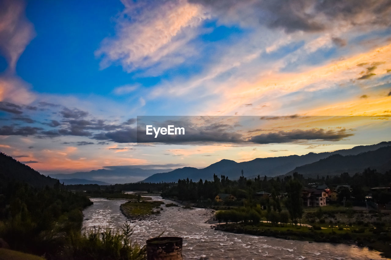 SCENIC VIEW OF RIVER BY MOUNTAINS AGAINST SKY