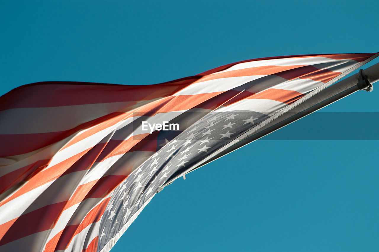 Close-up of american flag against clear blue sky