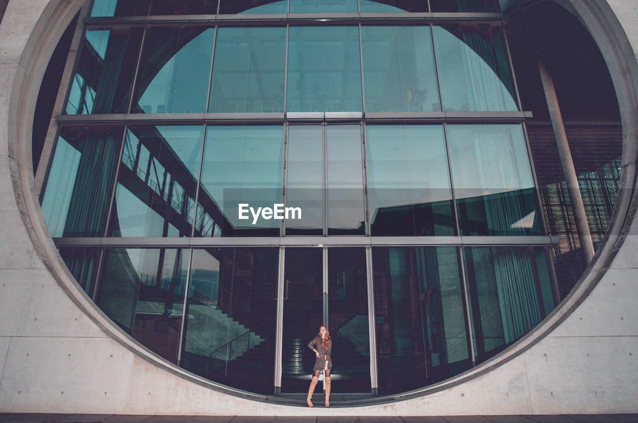 Young woman standing on circular window