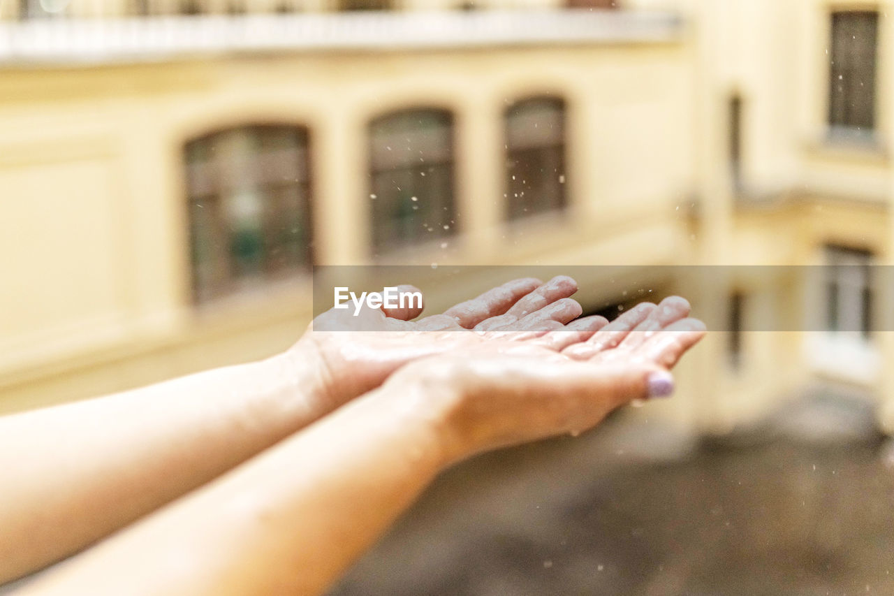 Women's hands in the rain, raindrops fall into their hands, catch.