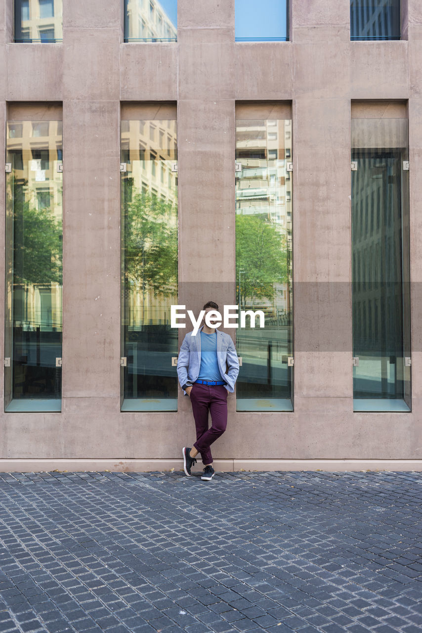 Full length of man standing against building in city