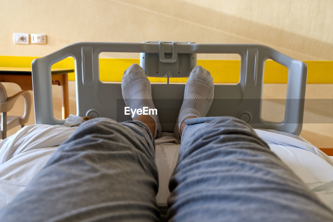 Concept health and medicine, selfie of feet with white socks of a patient sitting in a hospital bed